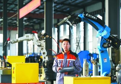 图为该公司技术人员在调试焊接机器人产品。